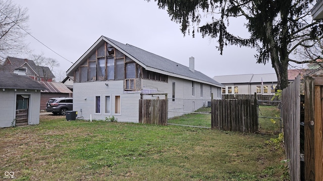 back of property featuring cooling unit and a lawn