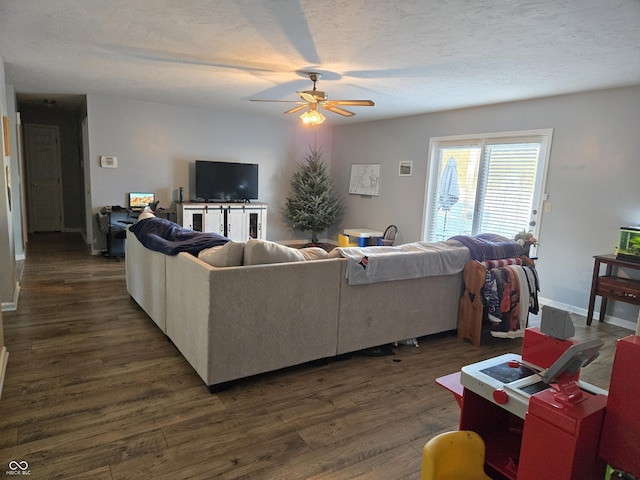 living room with dark hardwood / wood-style flooring, a textured ceiling, and ceiling fan