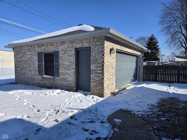 snow covered property with a garage