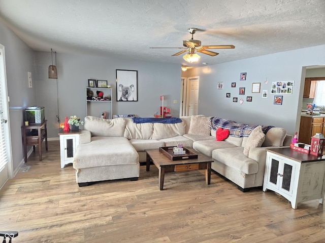 living room with a healthy amount of sunlight, ceiling fan, a textured ceiling, and light wood-type flooring