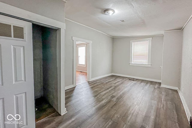 unfurnished room with dark hardwood / wood-style flooring, lofted ceiling, a textured ceiling, and ornamental molding