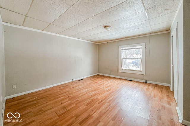 unfurnished room featuring light hardwood / wood-style flooring and a drop ceiling