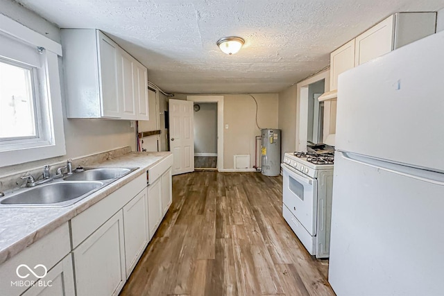 kitchen featuring white cabinetry, water heater, sink, and white appliances