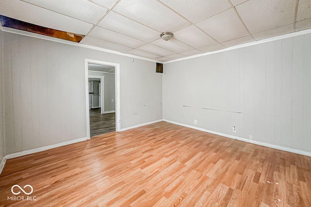 spare room with hardwood / wood-style flooring and a paneled ceiling