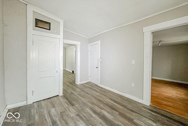 unfurnished bedroom featuring hardwood / wood-style flooring, a closet, ornamental molding, and vaulted ceiling