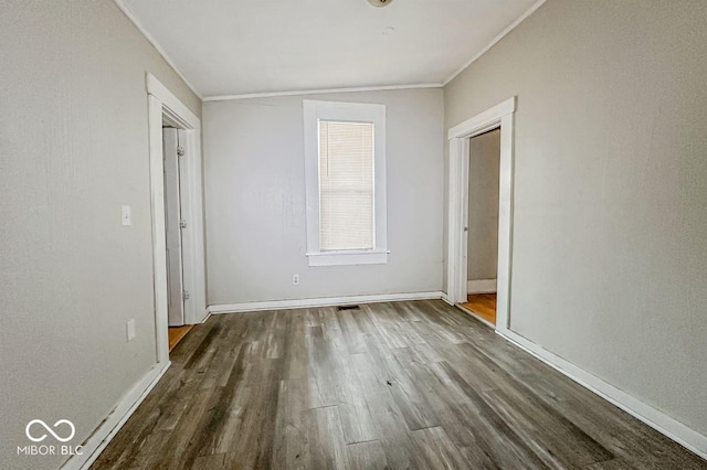 unfurnished bedroom featuring dark hardwood / wood-style floors, a closet, and crown molding