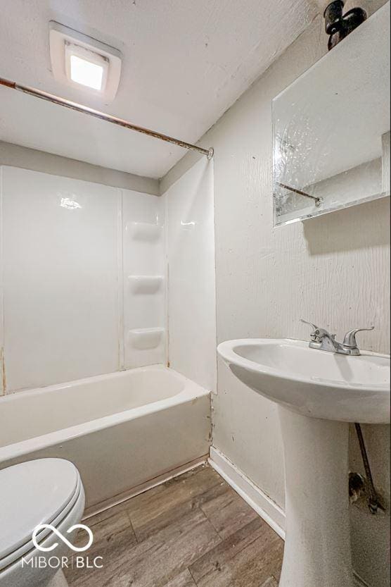 full bathroom with wood-type flooring, toilet, shower / tub combination, and sink