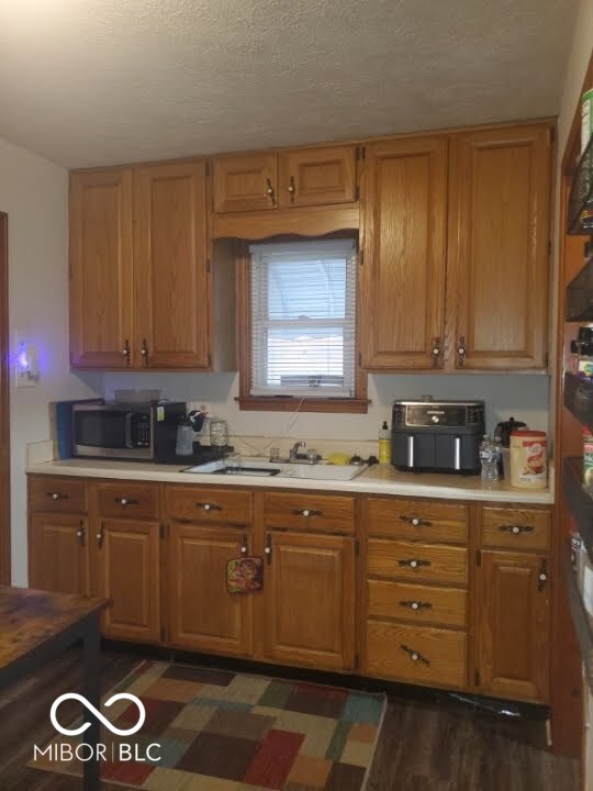 kitchen featuring dark hardwood / wood-style flooring and a textured ceiling