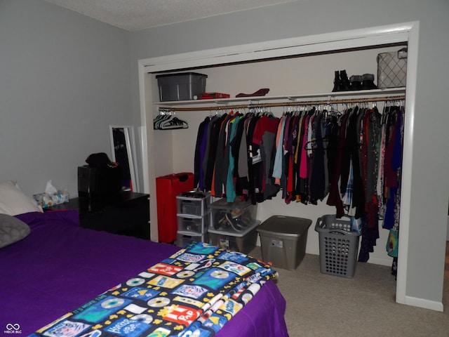 bedroom featuring carpet floors, a textured ceiling, and a closet