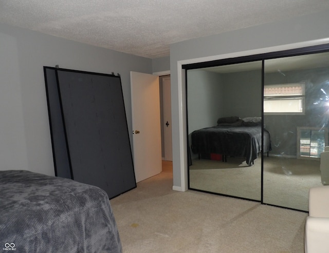 carpeted bedroom featuring a textured ceiling and a closet