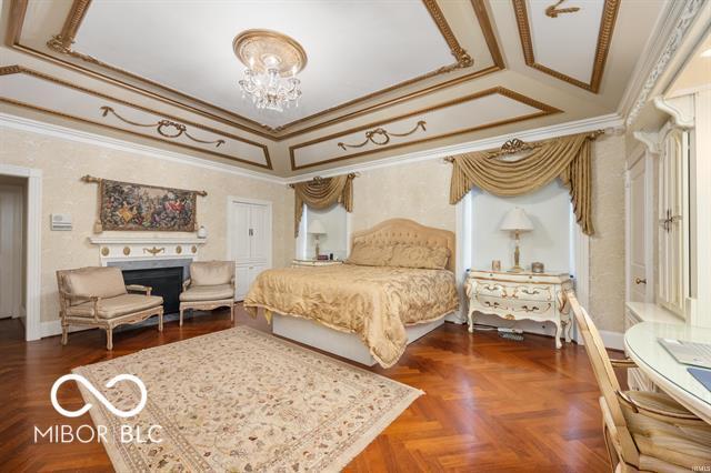 bedroom featuring dark parquet flooring, crown molding, and a chandelier