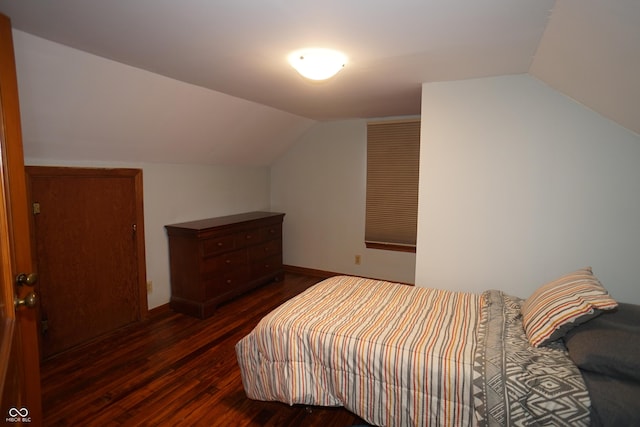 bedroom with vaulted ceiling and dark hardwood / wood-style floors