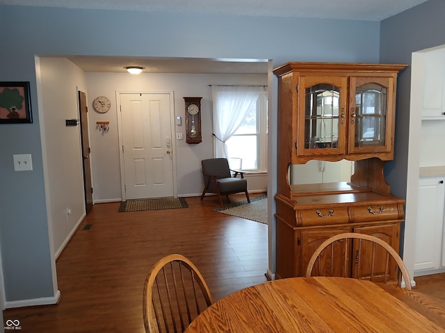 unfurnished dining area featuring dark wood-type flooring