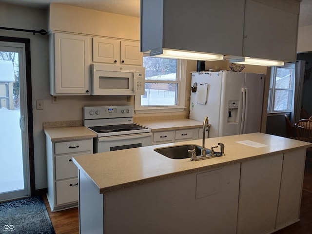 kitchen featuring white appliances, a kitchen island with sink, a healthy amount of sunlight, and sink