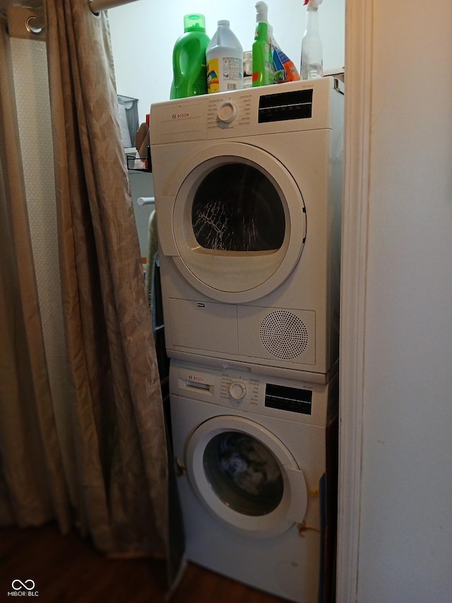 washroom featuring stacked washer and clothes dryer