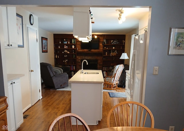 dining area featuring built in shelves, light wood-type flooring, and sink