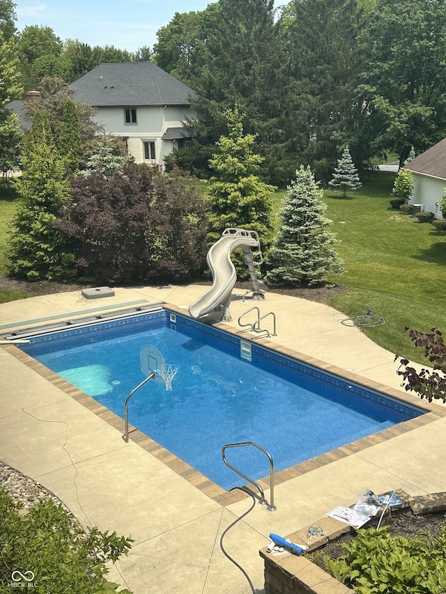 view of swimming pool with a lawn and a water slide