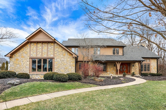 view of front of house featuring roof with shingles and a front yard