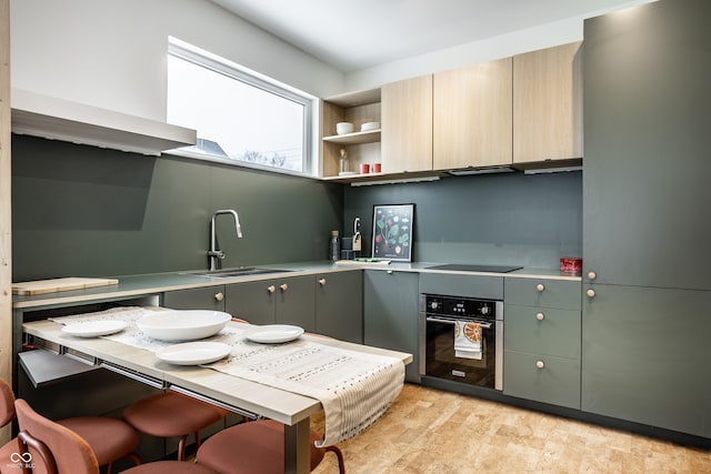 kitchen featuring black electric stovetop, oven, and sink