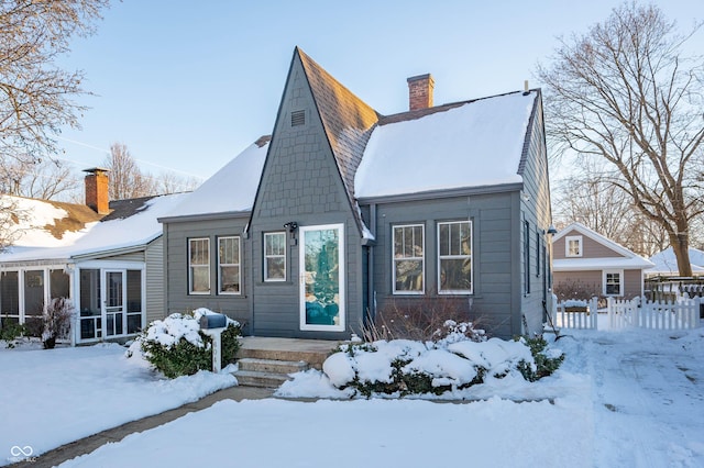 snow covered property featuring a sunroom