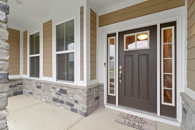 property entrance with stone siding and covered porch