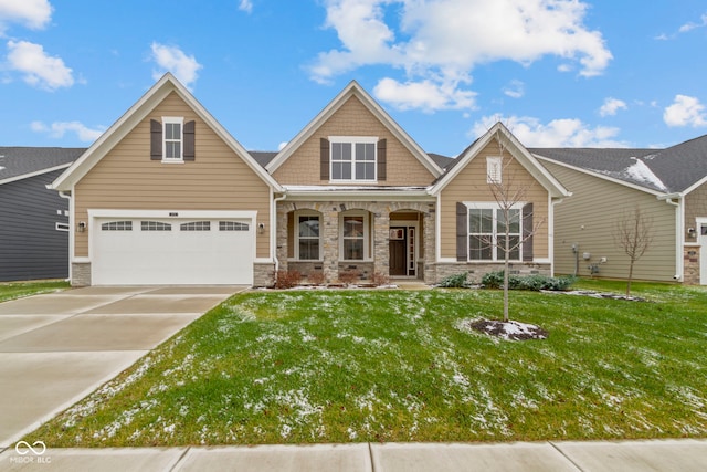 craftsman-style house featuring a garage, driveway, stone siding, and a front yard