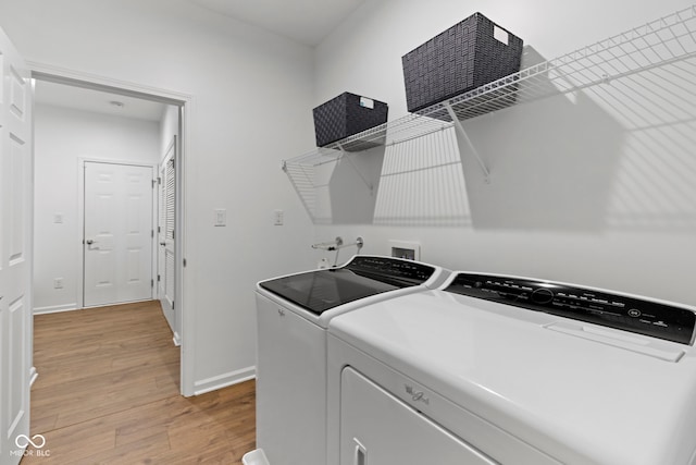 washroom with washer and dryer, laundry area, light wood-style flooring, and baseboards