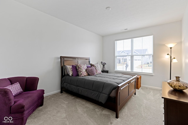 bedroom featuring light carpet and baseboards