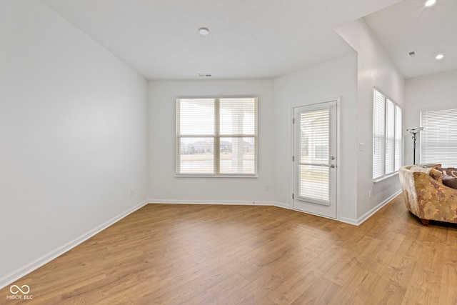 unfurnished living room featuring light wood-style floors, visible vents, and baseboards