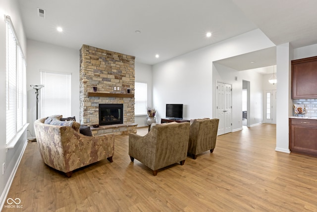 living area with recessed lighting, visible vents, a fireplace, and light wood-style flooring