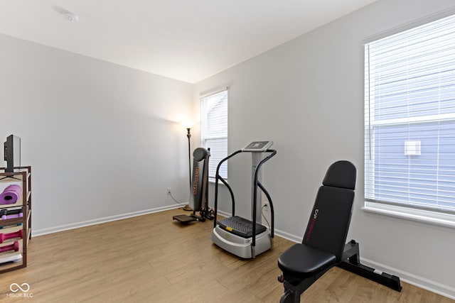 workout area featuring light wood-style floors and baseboards