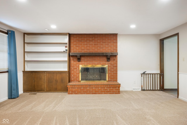 unfurnished living room featuring a fireplace and light colored carpet