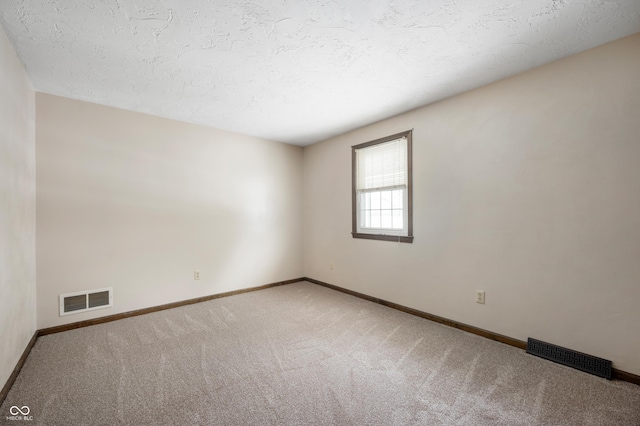 carpeted spare room featuring a textured ceiling