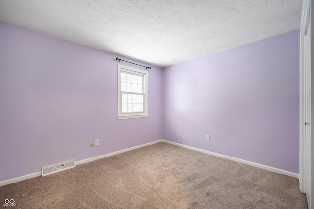 carpeted spare room featuring a textured ceiling