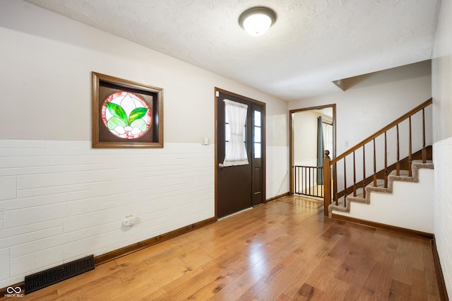 foyer entrance with a textured ceiling and hardwood / wood-style flooring