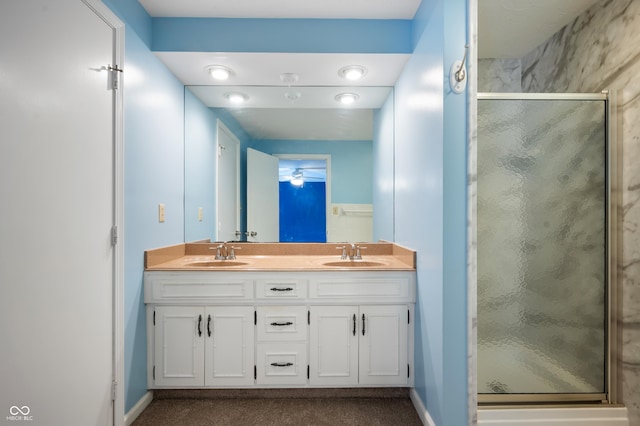 bathroom with a shower with door and vanity