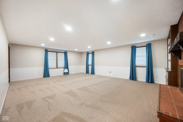 carpeted spare room featuring a fireplace