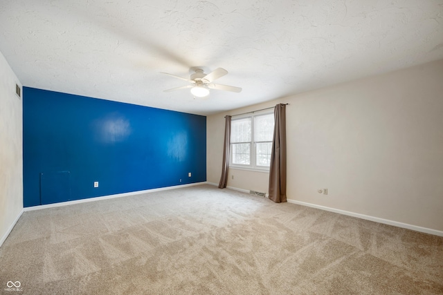 empty room with light carpet, a textured ceiling, and ceiling fan