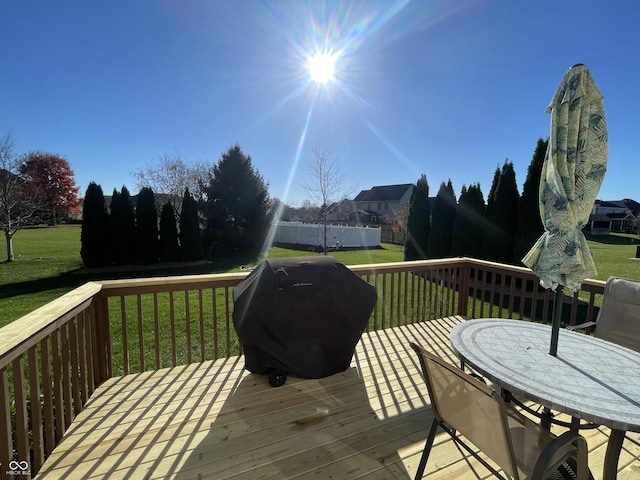 wooden deck featuring a yard and a grill