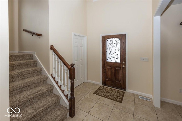 entryway featuring a towering ceiling and light tile patterned flooring