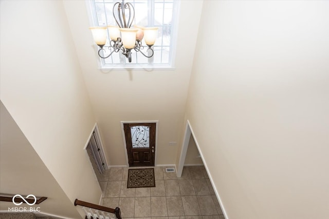 entryway featuring a chandelier and a towering ceiling