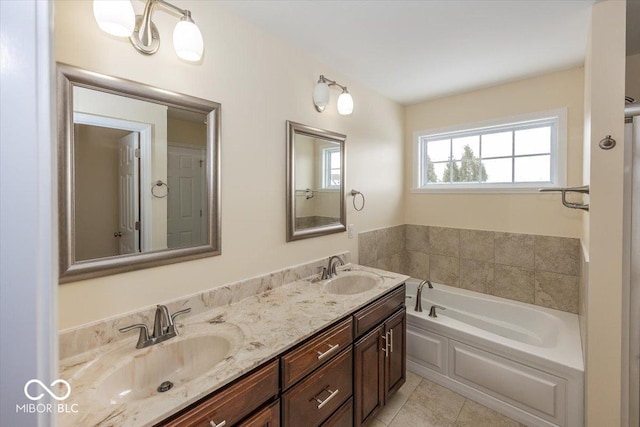 bathroom with a tub to relax in, tile patterned floors, and vanity