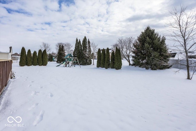 yard covered in snow with a playground