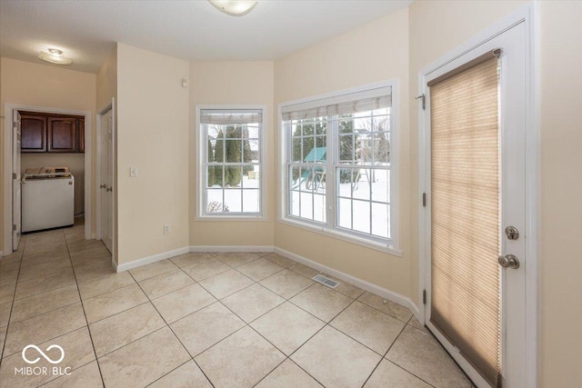 interior space featuring washer / dryer and light tile patterned floors