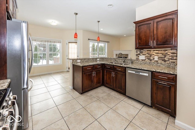 kitchen with sink, hanging light fixtures, tasteful backsplash, kitchen peninsula, and stainless steel appliances