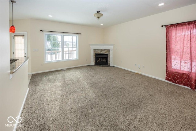 unfurnished living room featuring carpet flooring and a tile fireplace