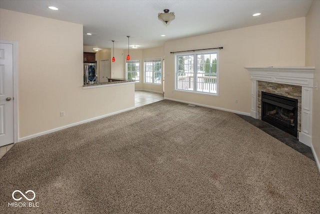 unfurnished living room featuring dark carpet and a tiled fireplace