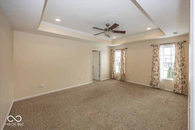 unfurnished room with carpet flooring, ceiling fan, crown molding, and a tray ceiling