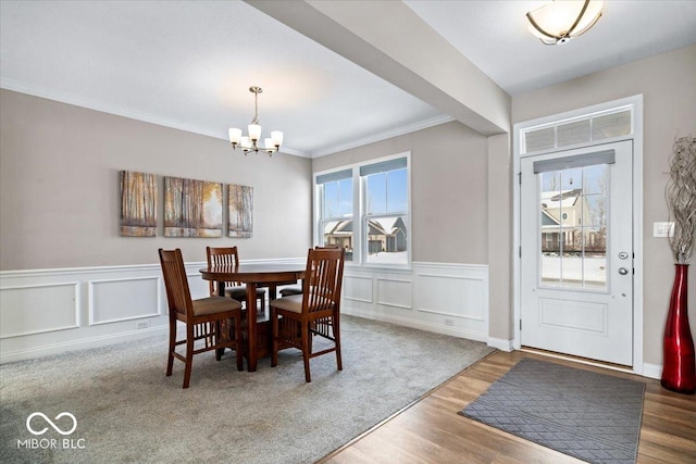 dining room featuring an inviting chandelier, crown molding, and wood-type flooring