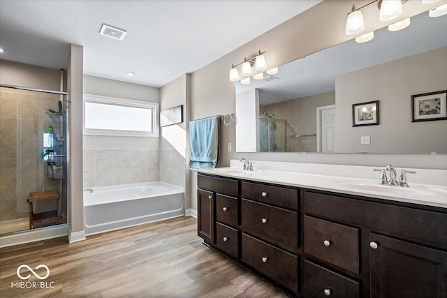 bathroom featuring independent shower and bath, wood-type flooring, and vanity